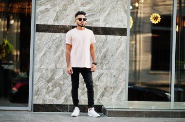Güneş gözlüğü ve pembe tişört şık Hint sakallı adam. Hindistan modeli şehrin sokaklarında, açık poz verdi.