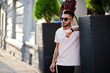 Güneş gözlüğü ve pembe tişört şık Hint sakallı adam. Hindistan modeli şehrin sokaklarında, açık poz verdi.