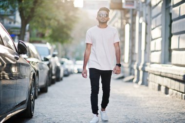 Güneş gözlüğü ve pembe tişört şık Hint sakallı adam. Hindistan model şehrin sokaklarında yürüyüş açık günbatımı.