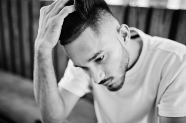 Pembe tişört Cafe ahşap tablo karşı oturup şık Hint sakallı adam. Hindistan modeli açık poz verdi. Portre kadar kapatın.