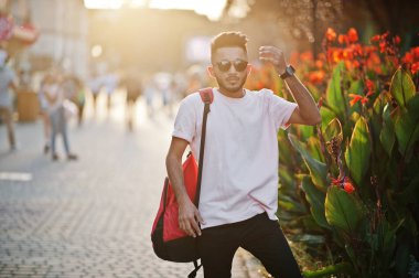 Pembe tişört, güneş gözlüğü ve sırt çantası şık Hint sakallı adam. Hindistan modeli günbatımı şehrin sokaklarında, açık poz verdi.