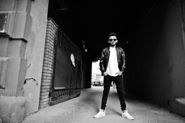 Siyah deri ceket ve tonnel kemer, güneş gözlüğü, şık Hint sakallı adam. Hindistan modeli şehrin sokaklarında, açık poz verdi.