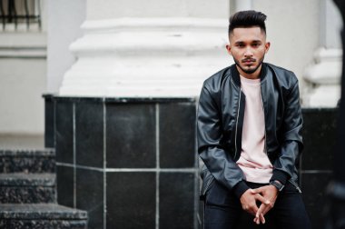 Siyah deri ceket şık Hint sakallı adam. Şehrin sokaklarında oturmuş poz Hindistan modeli.