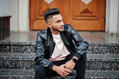 Siyah deri ceket şık Hint sakallı adam. Şehrin sokaklarında oturmuş poz Hindistan modeli.