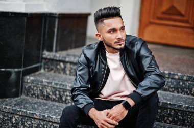 Siyah deri ceket şık Hint sakallı adam. Şehrin sokaklarında oturmuş poz Hindistan modeli.
