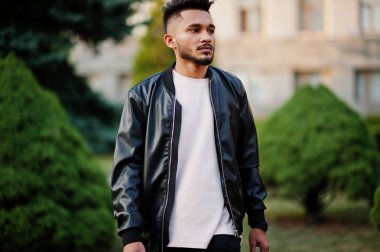 Siyah deri ceket şık Hint sakallı adam. Hindistan modeli şehir yeşil bahçe poz verdi..