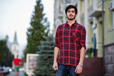 Genç Hintli öğrenci adam kırmızı kareli gömlek ve pantolon city adlı poz verdi..