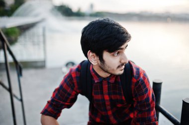 Akşam şehre çeşmeler karşı üzerinde kareli gömlek ve sırt çantası ile kot Genç Hintli öğrenci adama poz.