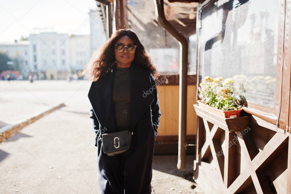 Stylish african american girl in blue coat and sunglasses posed at sunny autumn day. Africa model woman.
