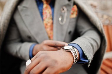 Şık Afro-Amerikan man modeli gri ceket, onun saatler seyir ceket kravat.
