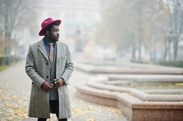 グレーのコート ジャケット ネクタイと赤い帽子の通り霧で提起されたスタイリッシュなアフリカ系アメリカ人モデル — ストック写真