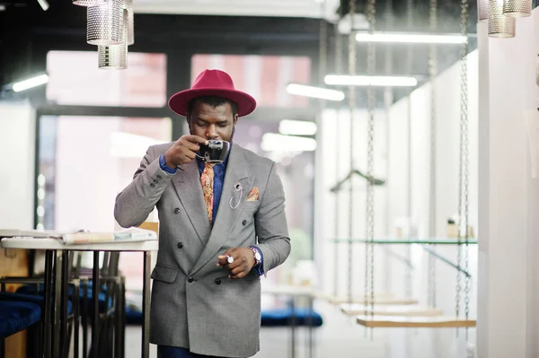 グレーのジャケット ネクタイと赤い帽子飲み物コーヒー カフェ 読む新聞でスタイリッシュなアフリカ系アメリカ人モデル — ストック写真
