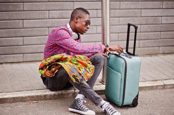 格子縞のシャツ サングラス スーツケースとバックパックのイヤホンでアフリカ系アメリカ人 黒人男性旅行者 — ストック写真