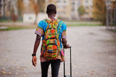 Sırt çantası ve bavul sonbahar park Afrika geleneksel forması Afrika adam. Göçmen gezgin.