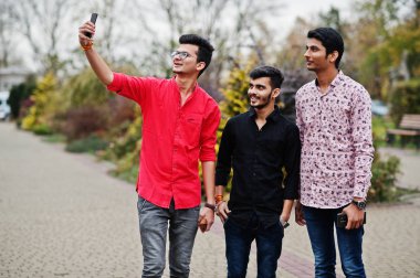 Sokak ve geçici selfie cep telefonu üzerinde yürüyen üç Hint çocuklar öğrenci arkadaşlar.