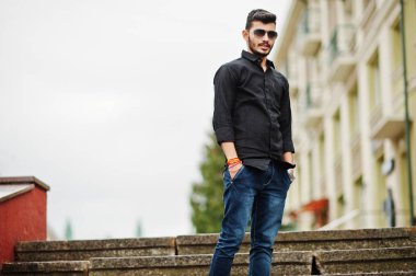 Siyah gömlek ve güneş gözlükleri şık Hintli açık poz verdi.