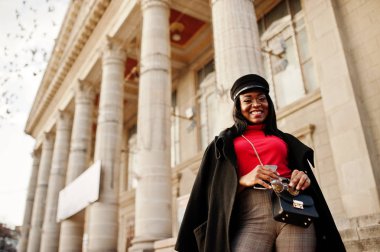 Ceket ve gazeteci çocuk şapkalı kız Afro-Amerikan moda Sokağı'nda poz verdi..