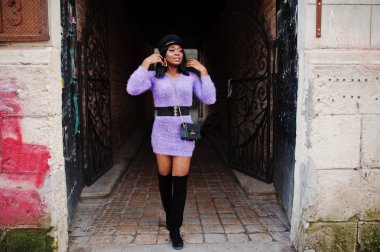 Afrikalı-Amerikalı kadın Mor elbise ve kapağı açık poz verdi.