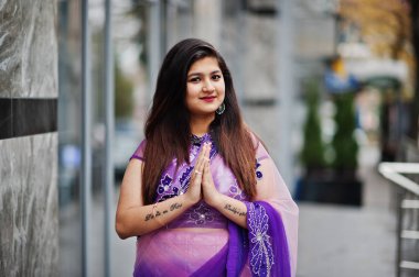 Geleneksel violet saree Hint hindu kıza Sokağı'nda yarattığı ve işareti gösterir namaste dövmesi eller.