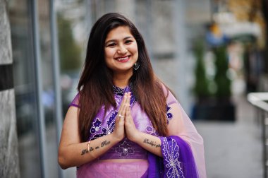 Geleneksel violet saree Hint hindu kıza Sokağı'nda yarattığı ve işareti gösterir namaste dövmesi eller.
