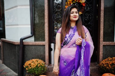 Geleneksel violet saree Hint hindu kıza Street Restoran Sonbahar ruh hali ve kabaklar kapı karşı poz verdi.