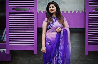 Geleneksel violet saree Hint hindu kıza Street mor windows karşı poz verdi.