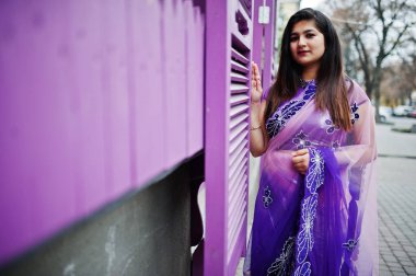 Geleneksel violet saree Hint hindu kıza Street mor windows karşı poz verdi.