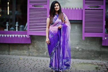 Geleneksel violet saree Hint hindu kıza Street mor windows karşı poz verdi.