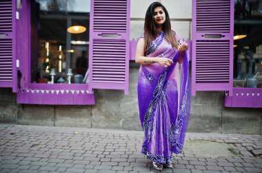 Geleneksel violet saree Hint hindu kıza Street mor windows karşı poz verdi.