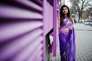 Geleneksel violet saree Hint hindu kıza Street mor windows karşı poz verdi.