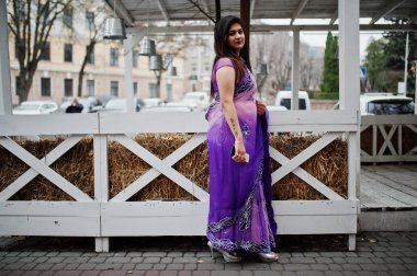 Geleneksel violet saree Hint hindu kıza karşı ahşap teras Street poz verdi.