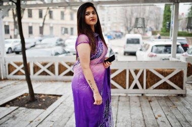 Geleneksel violet saree Hint hindu kıza karşı ahşap teras Street poz verdi.