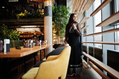 Restoranda poz siyah sari giysili güzel Hintli kız. 