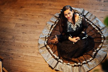 Siyah sari giysili güzel Hintli kız restoranda poz verdi. Yukarıdan görüntülemek.