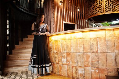 Restoranda poz siyah sari giysili güzel Hintli kız. 