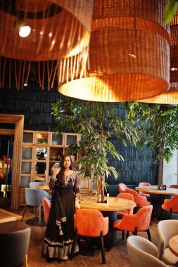 Restoranda poz siyah sari giysili güzel Hintli kız. 