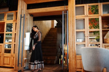 Restoranda poz siyah sari giysili güzel Hintli kız. 