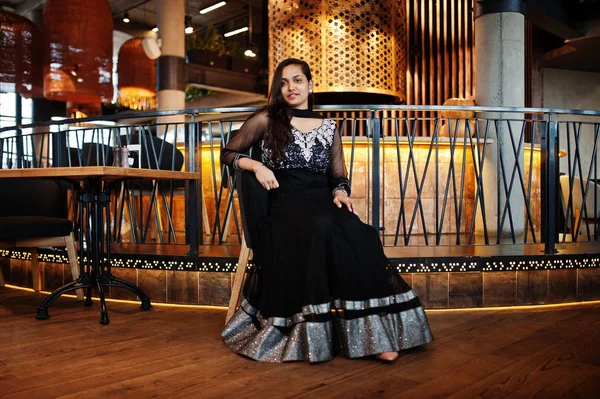 レストランでは 椅子に座ってポーズをとった黒サリー ドレスはかなりインドの少女 — ストック写真