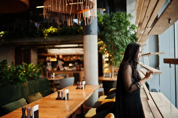 Restoranda poz siyah sari giysili güzel Hintli kız. 