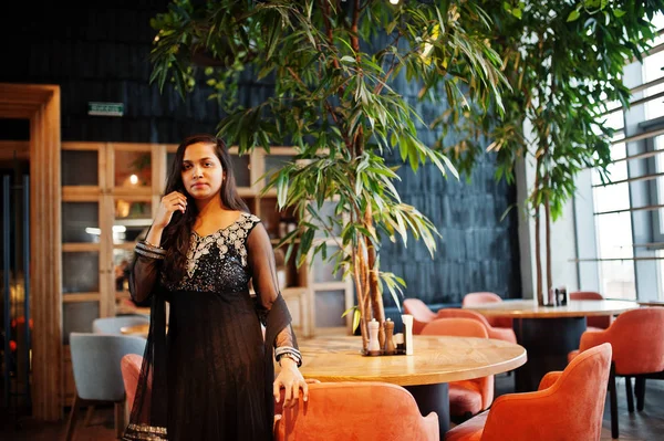 Restoranda poz siyah sari giysili güzel Hintli kız. 