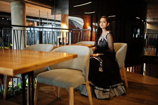 Restoranda poz siyah sari giysili güzel Hintli kız. 