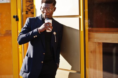 İnanılmaz Afro-Amerikan erkek giyimi mavi ceket broş ile seyir, siyah boğazlı kazak ve gözlük Sokağı'nda poz verdi. Zenci adamla moda: kahve.