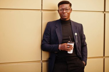 İnanılmaz Afro-Amerikan erkek giyimi mavi ceket broş ile seyir, siyah boğazlı kazak ve gözlük Sokağı'nda poz verdi. Zenci adamla moda: kahve.