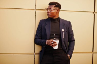 İnanılmaz Afro-Amerikan erkek giyimi mavi ceket broş ile seyir, siyah boğazlı kazak ve gözlük Sokağı'nda poz verdi. Zenci adamla moda: kahve.