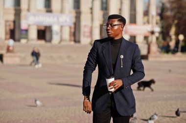 İnanılmaz Afro-Amerikan erkek giyimi mavi ceket broş ile seyir, siyah boğazlı kazak ve gözlük Sokağı'nda poz verdi. Zenci adamla moda: kahve.