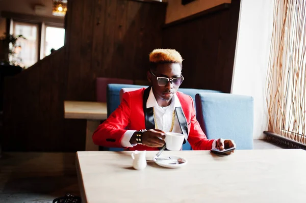 ハイライト髪とサングラスのカフェでコーヒーを飲みながら座っていると 赤いスーツでアフリカ系アメリカ人のファッションモデル — ストック写真