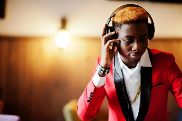 Fashion african american man model DJ at red suit with headphones.