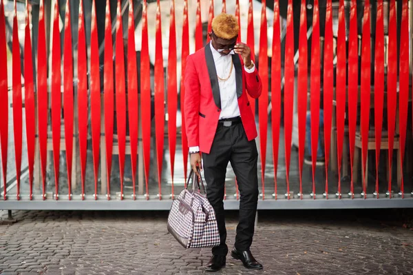 Kırmızı takım elbise, parlak nokta saç ve el çantası, Afro-Amerikan erkek manken Sokağı'nda poz verdi..