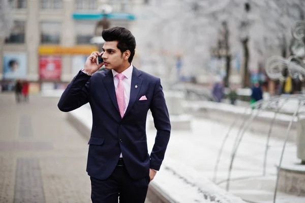 スーツにピンクのネクタイ冬の日に提起し 携帯電話で話す優雅なインドのマッチョな男モデル — ストック写真