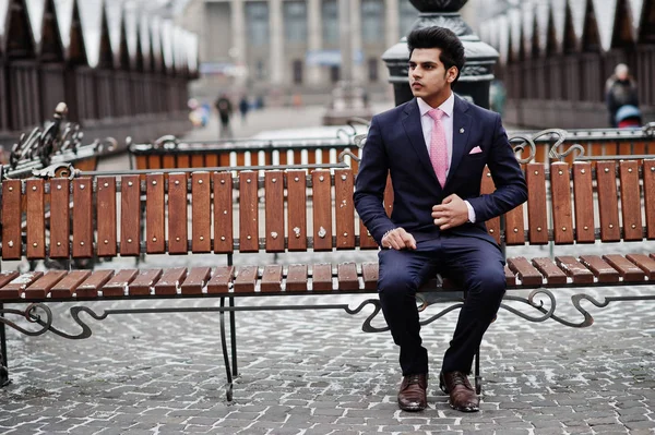 冬の日に提起し ベンチに座っているピンクのネクタイとスーツにエレガントなインドのマッチョな男モデル — ストック写真
